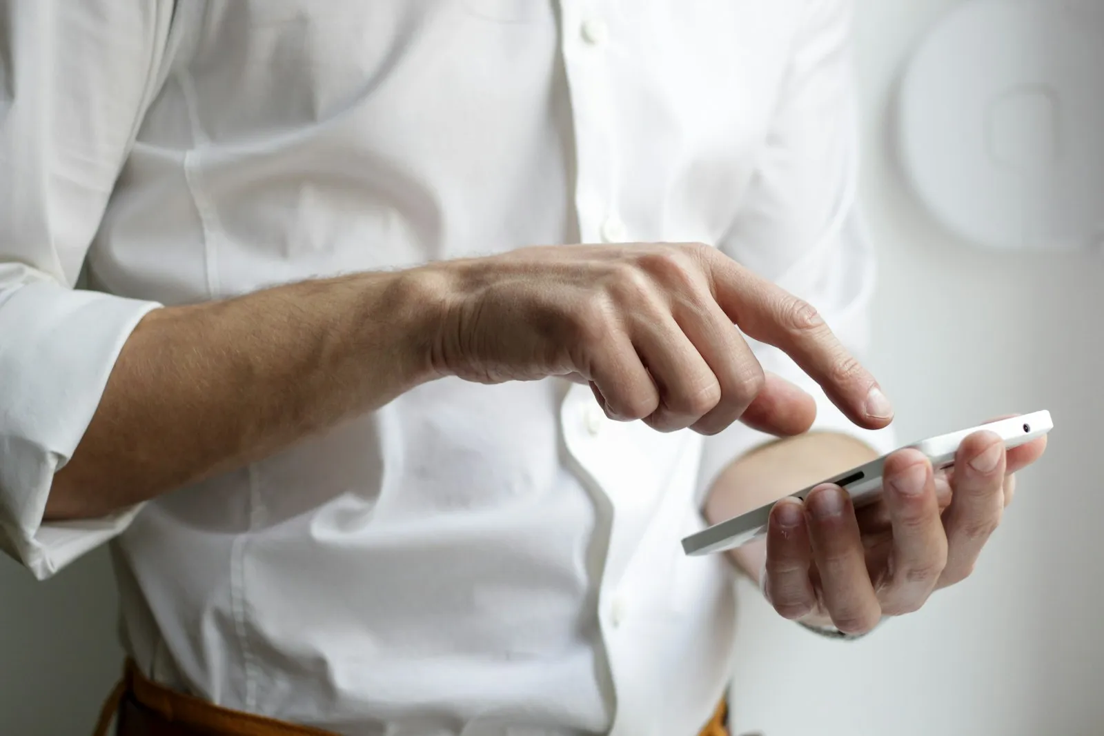 Person hält ein weißes Smartphone in der Hand